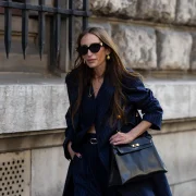 a woman wearing a navy blue striped coat and a hermes kelly bag