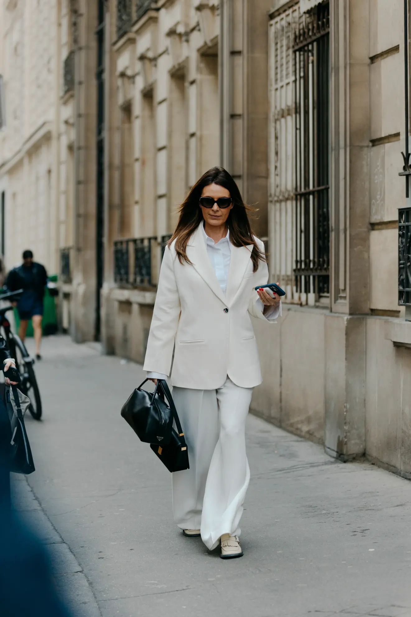 Parisian woman wearing a white suit with suede loafers