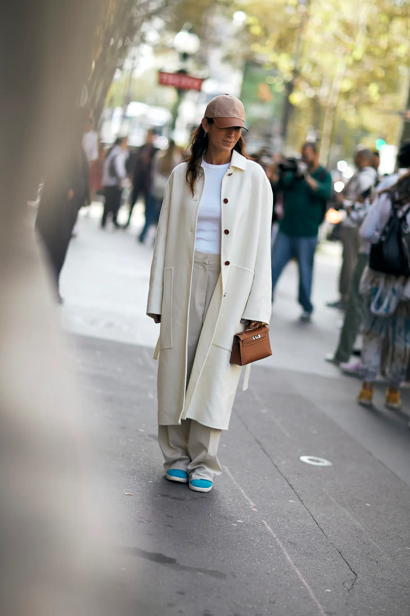 a woman at Paris fashion week street style wearing a cream overcoat and beige wide-leg pants 